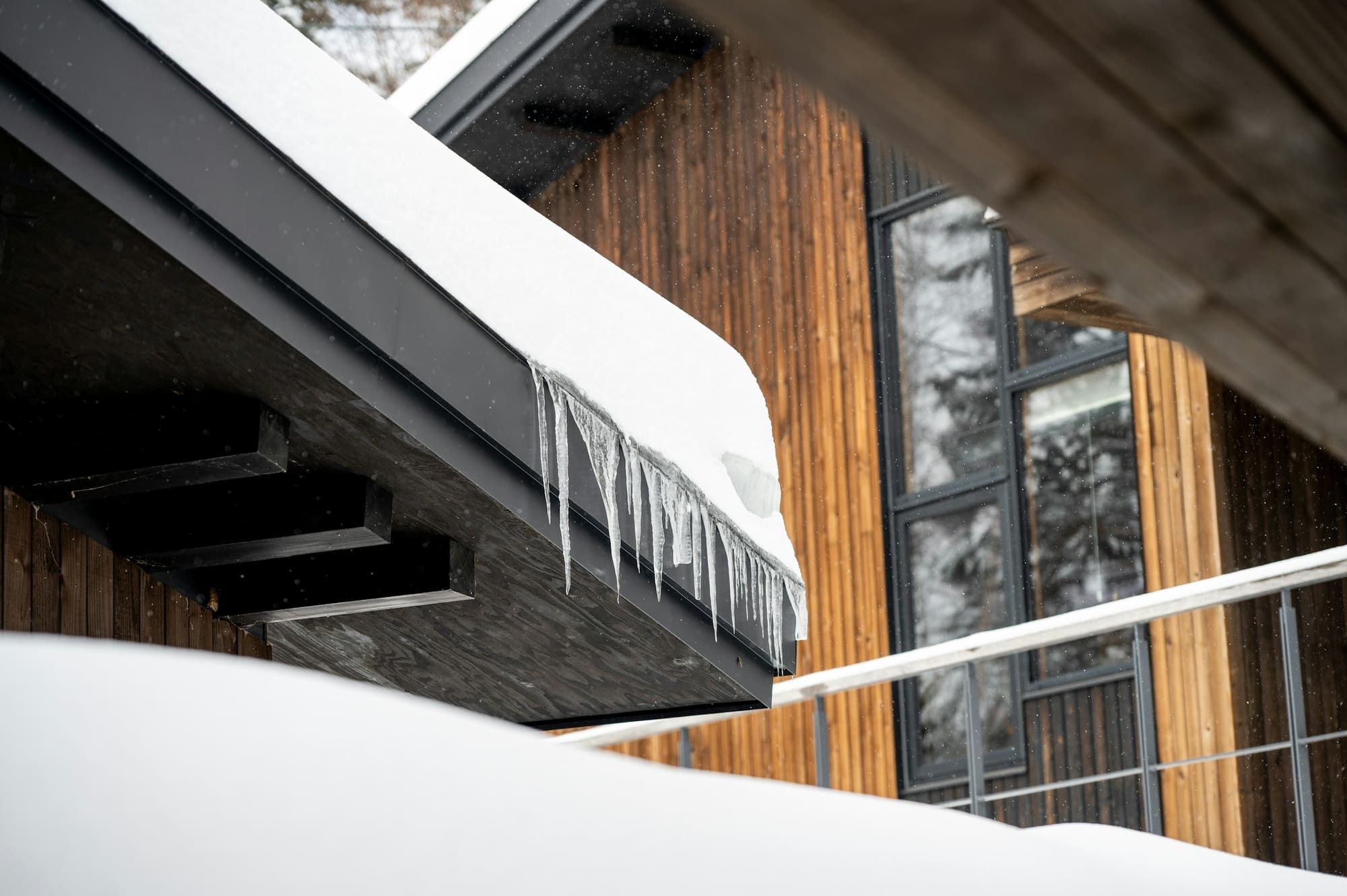 Icicles hanging from a snow-loaded roof eave
