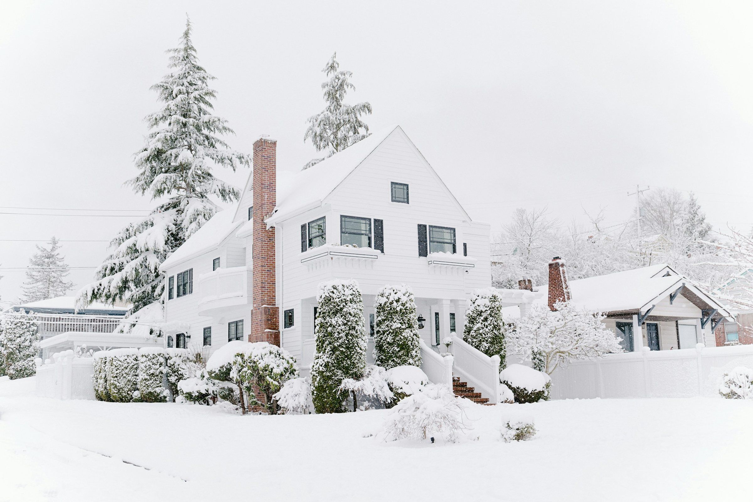 White house with a snow-covered roof after a winter storm