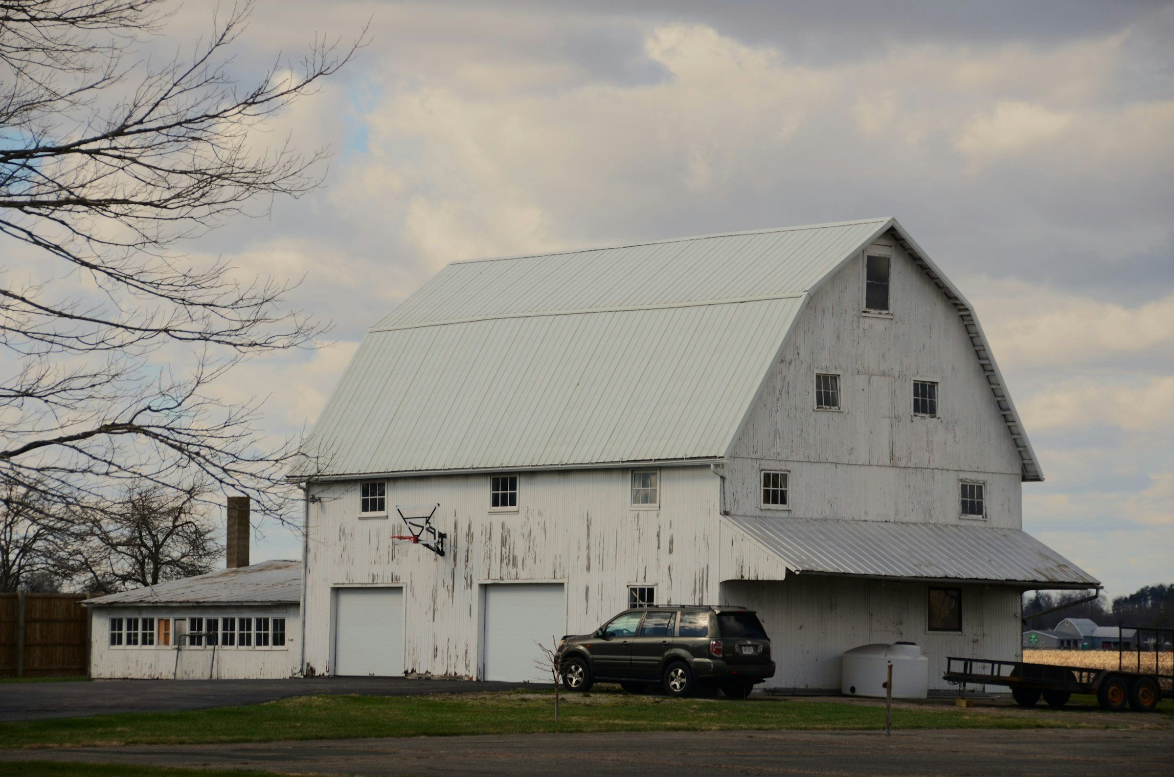White gambrel barn with a metal roof